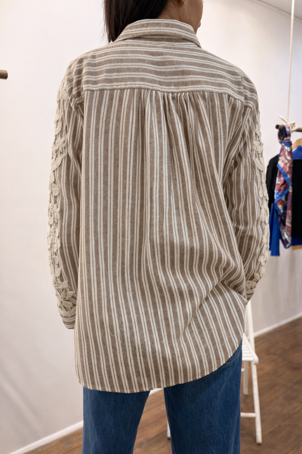 Blous_e STACEY rayée beige et écrue avec broderie florale écrue sur le devant et les manches, port_ée par une femme.