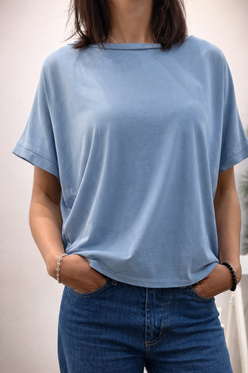 T-shirt ENZO bleu grisé porté par une femme – coupe fluide, manches revers, style casual chic.